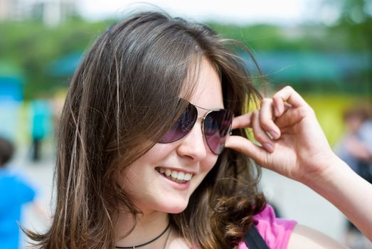 portrait of a smiling beautiful teenage girl in sunglasses