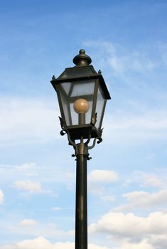 This image shows a street lamp with sky and clouds