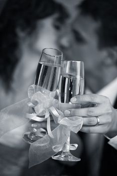 Glass of champagne in a hand of the groom and bride