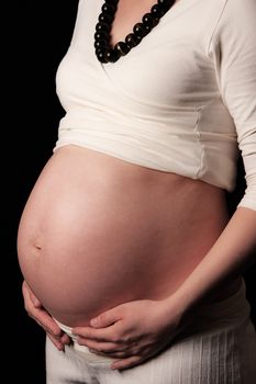 Pregnant mother holding belly exposing the bump