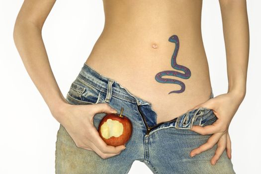 Portrait of attractive Caucasian young woman holding apple by snake tattoo on stomach.