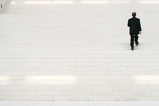 businessman in black suit going on stairs