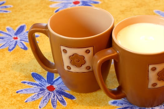 two cups on color background with flowers