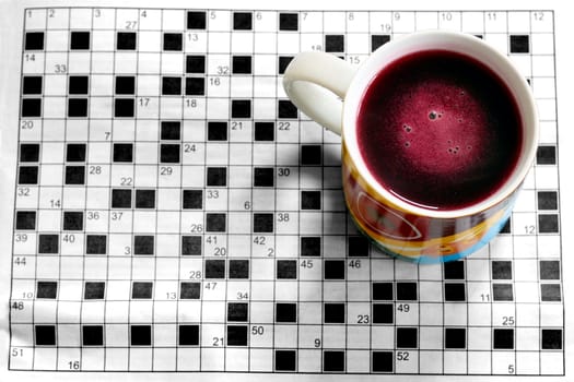A colourful cup with crossword in background