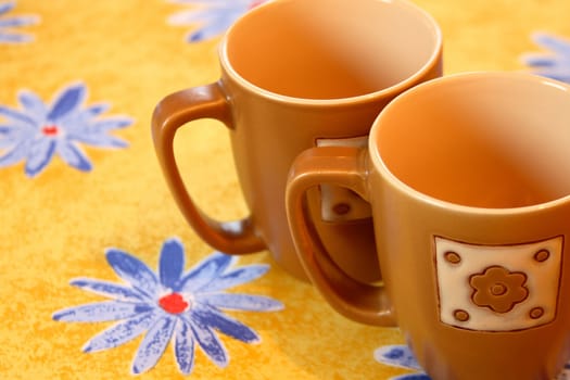 two empty cups on yellow background