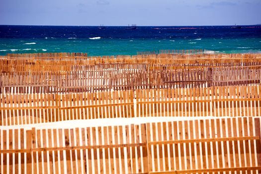 Wooden fence on deserted beach dunes in Tarifa, Spain