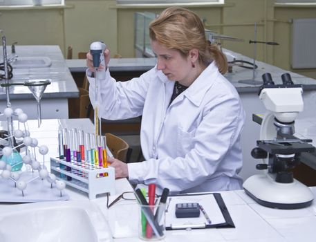Image of a researcher pipetting solutions into the tubes in a laboratory.