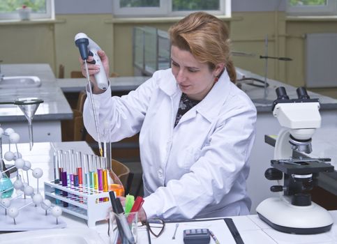 Image of a researcher pipetting solutions into the tubes in a laboratory.