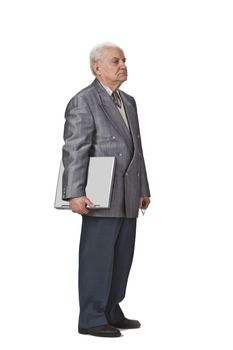 Image of a sehior man holding a laptop and standing-up against a white background,side view.