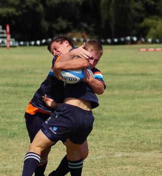 A tussle for the ball between to boys in a rugby football match (Editorial)