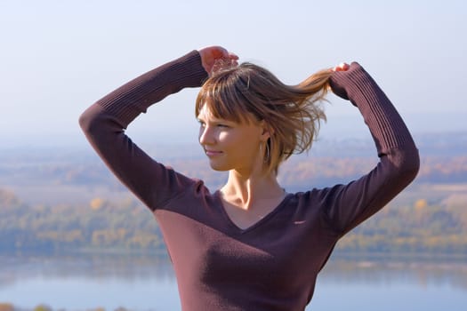 Portrait of the beautiful young girl against blue sky