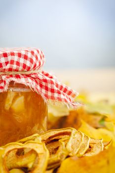 Full jar of apple jam on the leaves