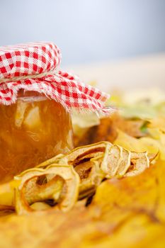 Full jar of apple jam on the leaves