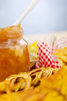 Full jar of apple jam on the leaves