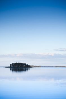 Alone island on the lake at sunset