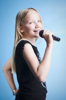 Young girl singing with microphone over blue background