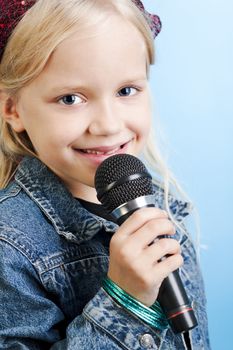 Young girl singing with microphone over blue background