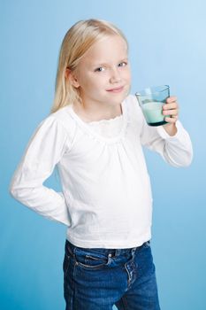 Young girl holding milk glass over a blue background