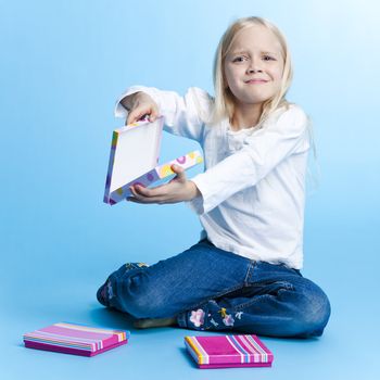 Young girl with unpleasant gift over blue background