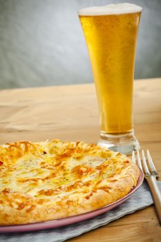 Hot pizza on the plate with cold beer