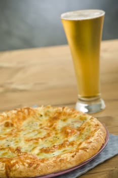 Hot pizza on the plate with cold beer