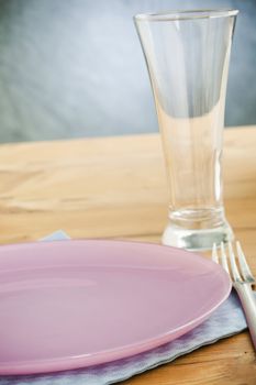 Empty plate and glass on the wooden table