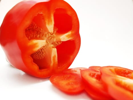Red pepper vegetable, sliced, closeup towards white background