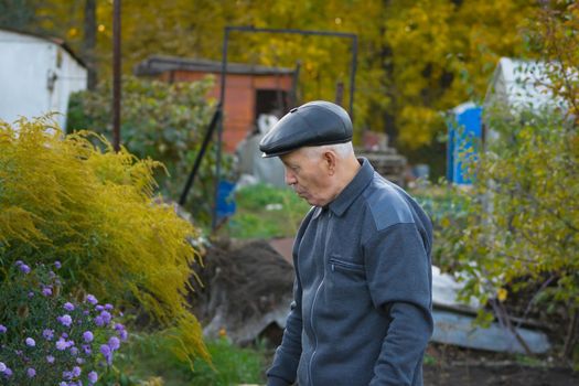 the elderly man in a cap against the nature