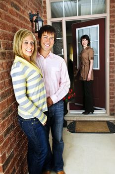 Real estate agent with couple welcoming to new home