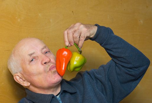 Portrait of the elderly man with red and green paprika