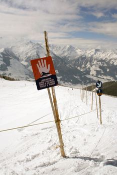 Avalanche warning sign on mountainside in Swiss Alps.
