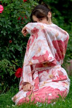 Girl in a pink yukata near rosebush
