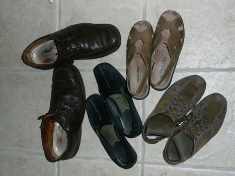 Pairs of old shoes lying on the floor.