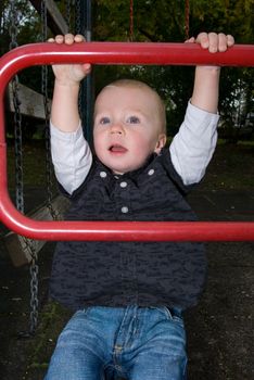 a little boy chinning the bar at the playground