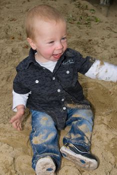 a little boy having fun in the sandbox