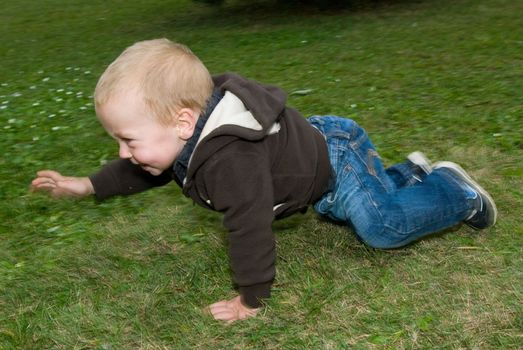 a little boy crawling on the lawn