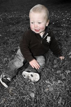a little boy sitting in the lawn