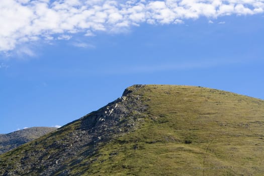 woodless slope and cloudly sky
