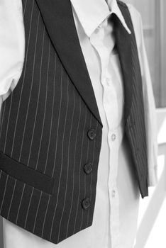 Closeup of the whire shirt and striped jacket. Side view. Black and white photo.