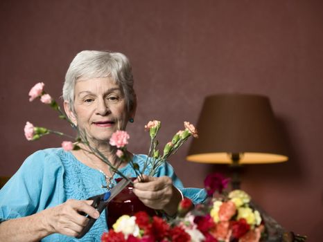 Senior woman at home with colorful flowers