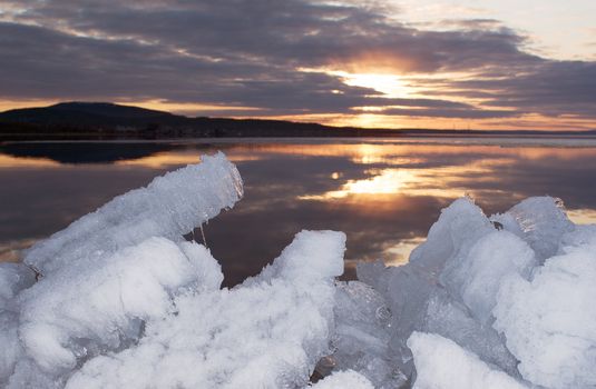 Last spring ice on northern lake in the evening