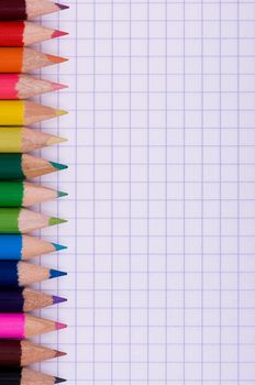 Close-up image of multicolor pencils on paper background