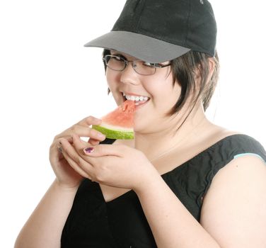 A young girl wearing a baseball cap is eating a slice of watermelon, isolated against a white background.