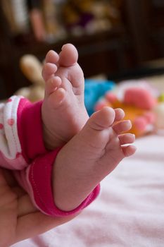 Baby girl feet in mother's hands
