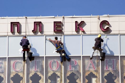 Cleaning team is washing windows of store. Taken in Moscow,Russia on April 2010