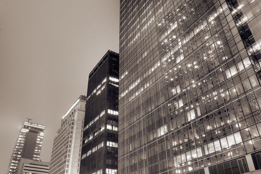 Cityscape of modern building exterior with glass windows in night.
