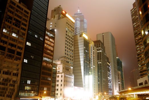 City night with skyscraper and office building in Hong Kong.