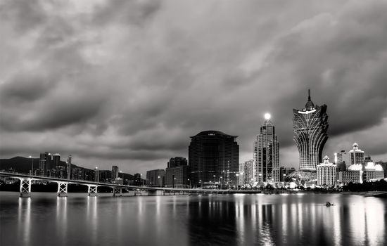 Cityscape in Macao with skyscraper and bridge in night.