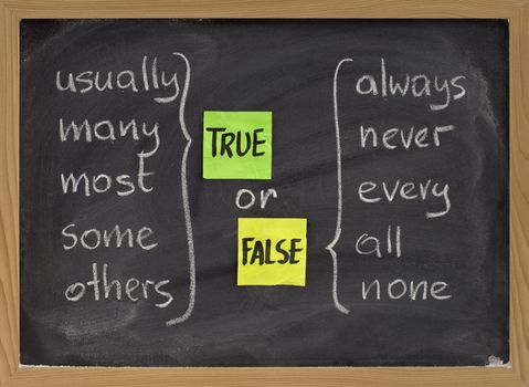 true or false concept, words commonly associated with truth (usually, many, most, some, others) and false (always, never, every, all, none) - color sticky notes and white chalk handwriting on blackboard