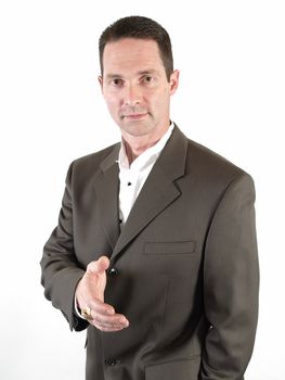 A clean cut man in a business suit stands with his arms folded.